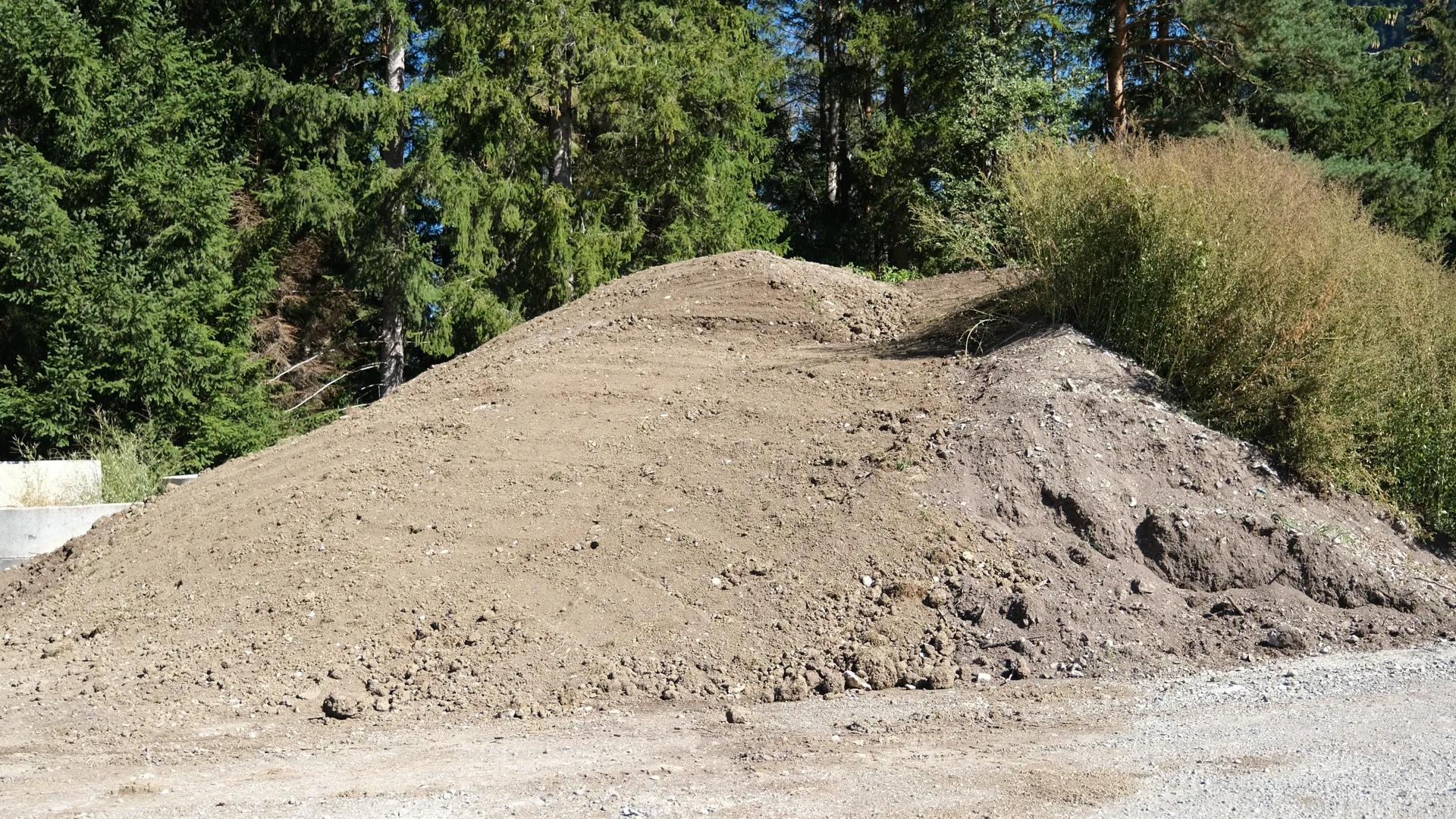 Haufen aus brauner Erde am Waldrand