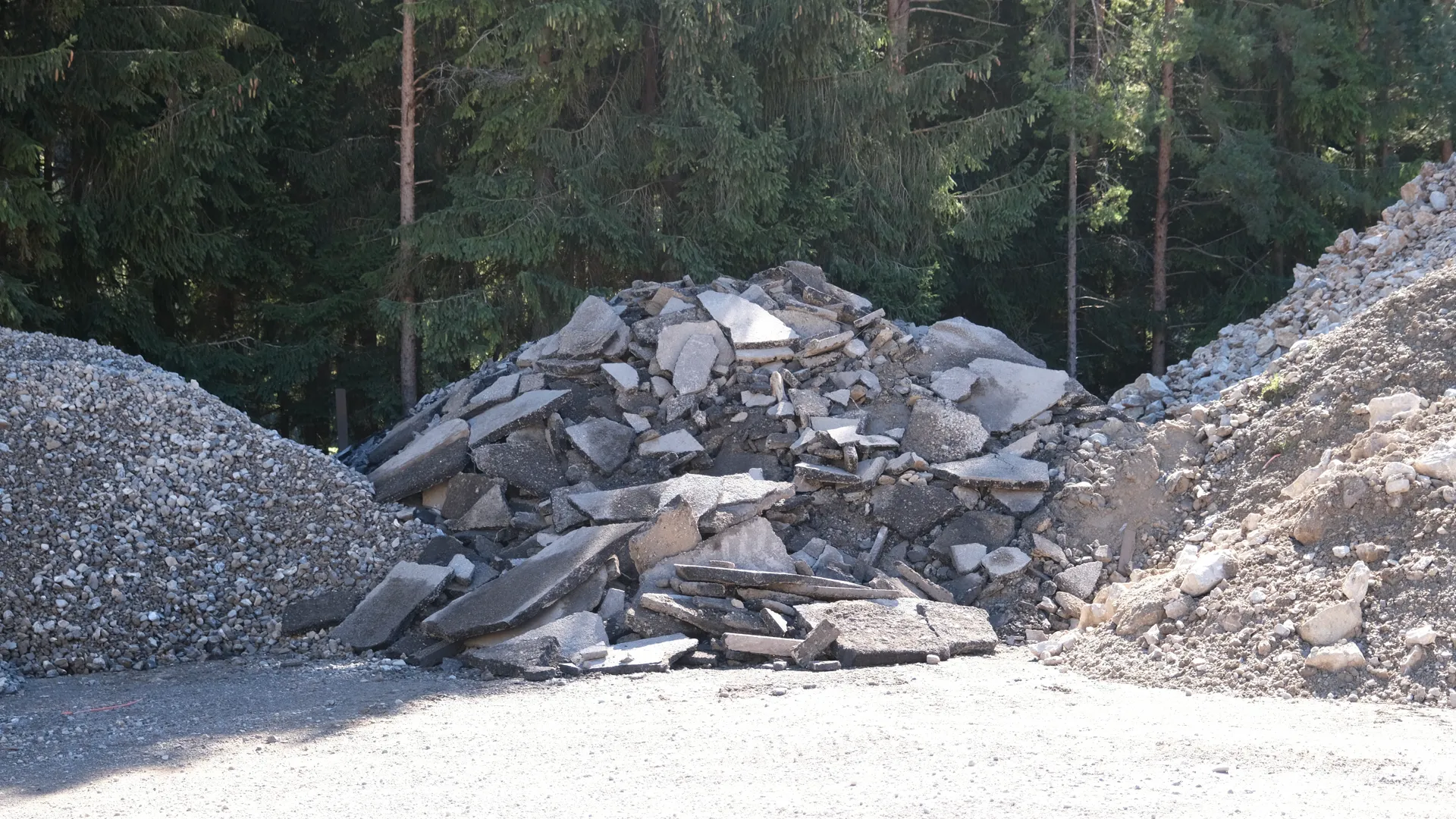Aufgeschichtete flache Bruchstücke zwischen zwei Schotterhaufen